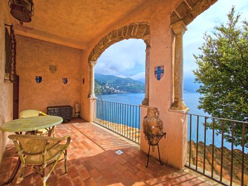 a balcony with a table and chairs and a view of the water at Villa Scarpariello Relais in Ravello