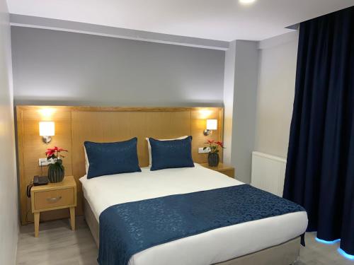 une chambre avec un grand lit avec des oreillers bleus dans l'établissement Liberi Hotel Taksim, à Istanbul