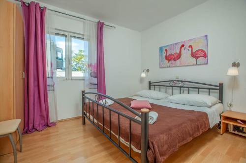 Schlafzimmer mit einem Bett und einem Fenster mit lila Vorhängen in der Unterkunft Luka 2 in Podgora