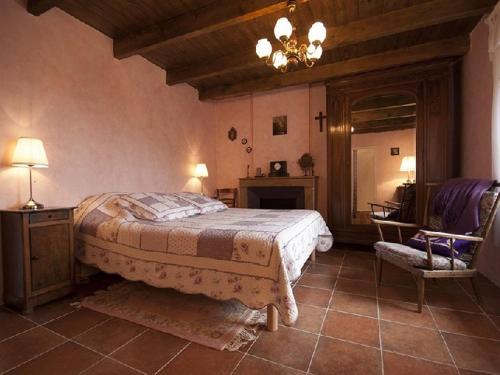 um quarto com uma cama grande e uma cadeira em Domaine de Cousignac em Bourg-Saint-Andéol