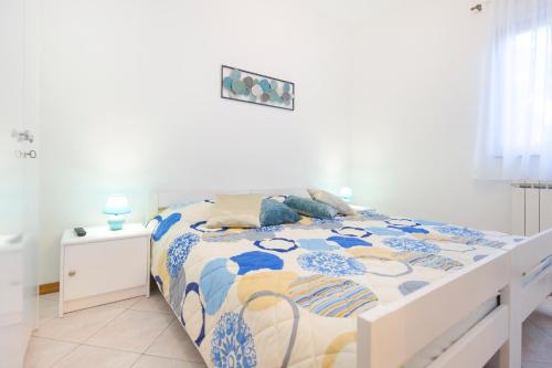 sypialnia z łóżkiem z niebiesko-białą kołdrą w obiekcie House Kontus w mieście Plomin