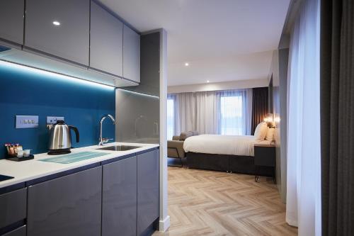 una cocina con fregadero y una cama en una habitación en Roomzzz York City en York