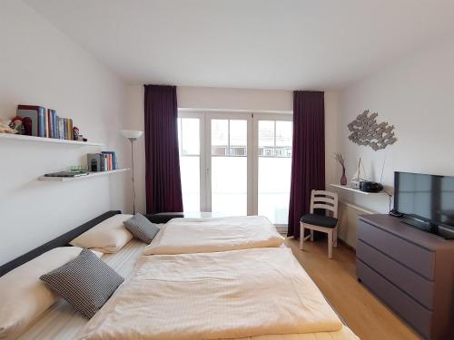 ウィトデュンにあるAuszeit am Meerのベッドルーム1室(ベッド2台、テレビ、デスク付)