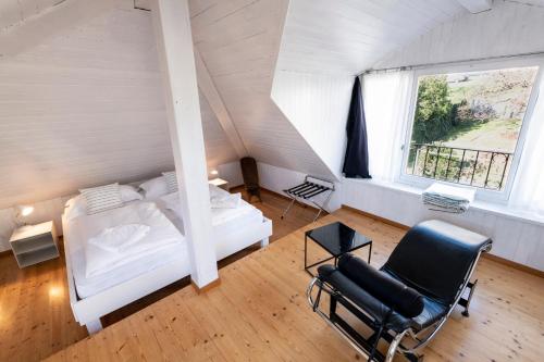 1 dormitorio con 1 cama, 1 silla y 1 ventana en B&B villa sempreverde, en Locarno