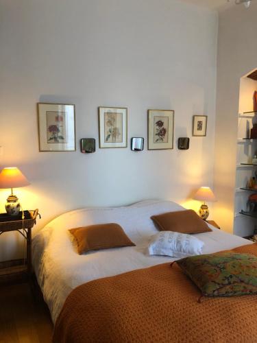 バスティアにあるAppartement Centre Ville Bastiaのベッドルーム1室(ベッド2台付)が備わります。壁に3枚の写真が飾られています。
