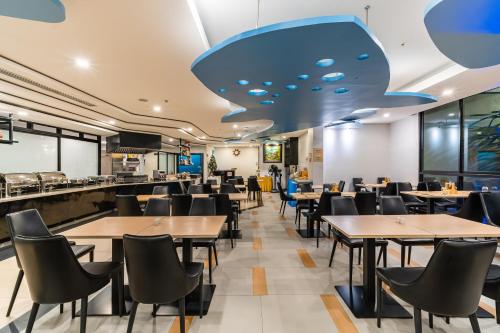 een eetkamer met tafels en stoelen bij LawinTa Hotel Pattaya in Jomtien Beach