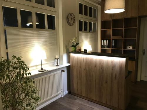 a lobby with a wooden door and a clock on the wall at Hotel und Restaurant Landhaus Veranstaltungshaus in Hohenwestedt