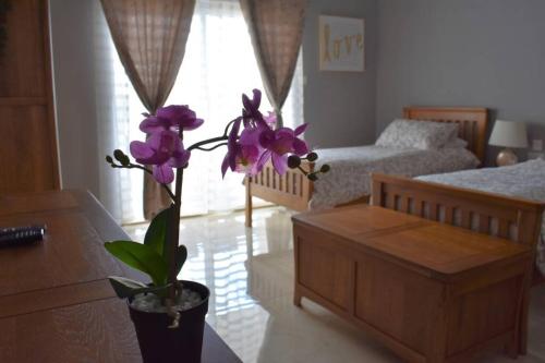 a living room with a vase with purple flowers in it at Modern Luxury villa in St. Julians in St Julian's
