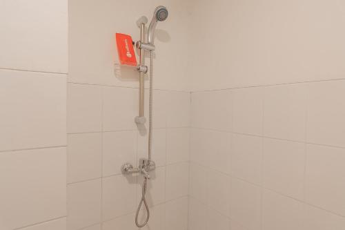 a shower with a shower head in a bathroom at RedDoorz Apartment @ Emerald Towers Bandung in Bandung