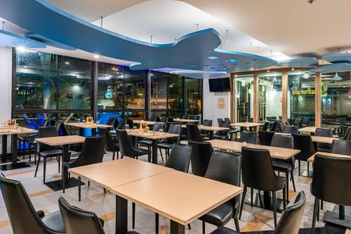 een eetkamer met tafels en stoelen bij LawinTa Hotel Pattaya in Jomtien Beach