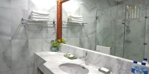 La salle de bains est pourvue d'un lavabo, d'un miroir et d'une douche. dans l'établissement Puri Padi, à Ubud