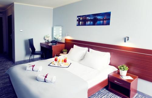 a hotel room with a bed with two drinks on it at Hotel Śląsk in Wrocław