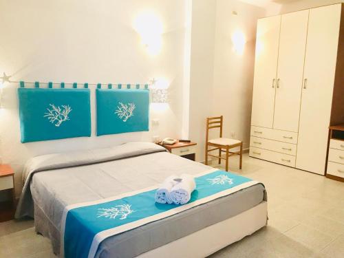 1 dormitorio con 1 cama con 2 toallas en Hotel Sandalion en Santa Teresa Gallura