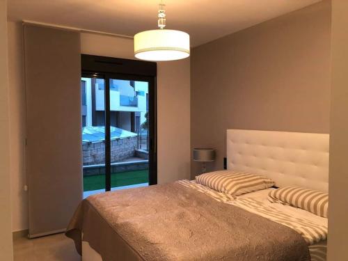 a bedroom with a large bed and a large window at Oasis Beach juan in Guardamar del Segura