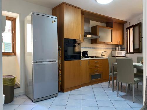 uma cozinha com um frigorífico e uma mesa com cadeiras em a casa mia holiday rental em Cetara