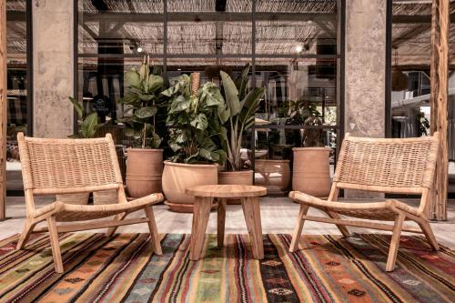 two chairs and a table in a room with plants at Caramelo Palma Beach in Playa de Palma