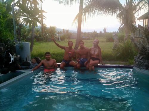 a group of people sitting in a swimming pool at Apollo Hostel in Lovina
