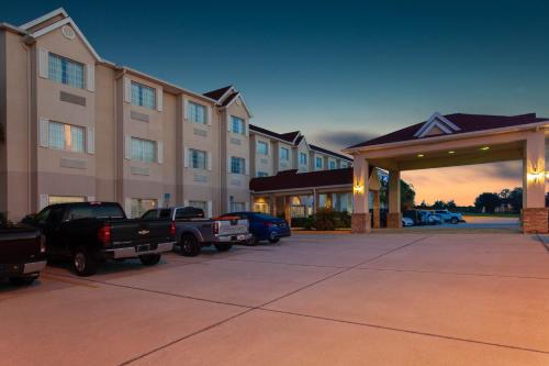 a large building with cars parked in a parking lot at Microtel Inn and Suites by Wyndham - Lady Lake/ The Villages in The Villages