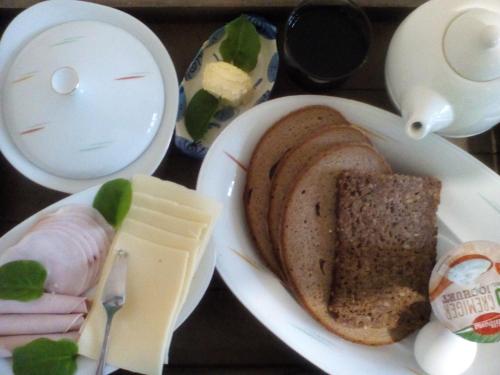 a white plate of food with a sandwich and cheese at Zöllnerhaus Nordhorn in Nordhorn