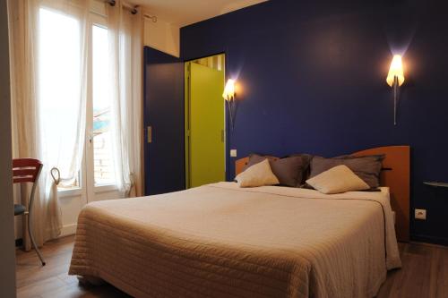 a bedroom with a large bed with a green door at Hôtel du Lac in Treignac