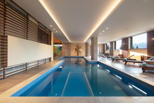 an indoor swimming pool with blue water in a house at Orizontes Tzoumerkon Hotel Resort in Pramanta
