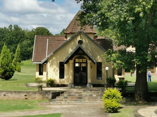 a small yellow house with a brown roof at Floreat Riverside Lodge and Spa in Sabie