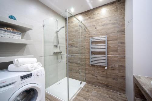 a bathroom with a washing machine and a glass shower at FEWO Sea View Porta Mare in Dziwnówek