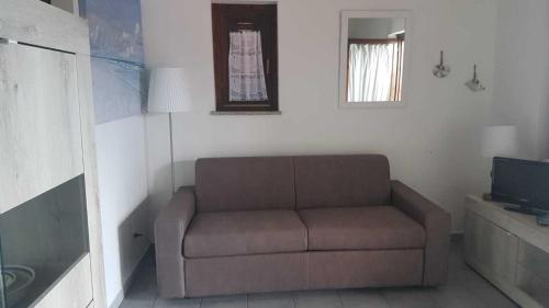 a living room with a couch and a television at Bilocale Li Menduli in San Teodoro