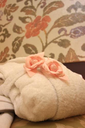 a towel with two pink roses on top of it at B&B Pretoria Suite in Potenza