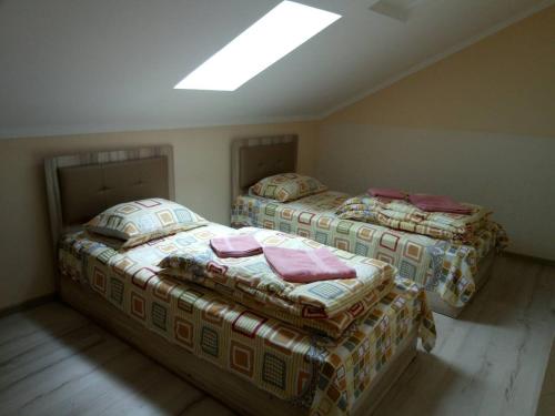 two twin beds in a room with a skylight at Згадка in Truskavets