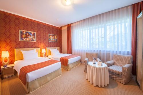 Habitación de hotel con 2 camas y mesa en Merotell en Krasnodar