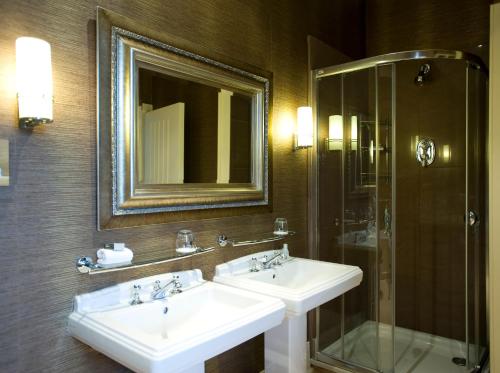 a bathroom with a sink, mirror, and bathtub at Mar Hall Golf & Spa Resort in Bishopton