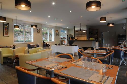 a dining room with tables and chairs and tablesktop at Hôtel du Lac in Treignac