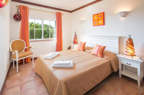 - une chambre avec un lit, une chaise et une fenêtre dans l'établissement Casa Mulholanda, à Benagil