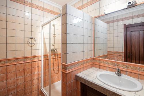 La salle de bains est pourvue d'un lavabo, d'une douche et d'un miroir. dans l'établissement Casa Mulholanda, à Benagil
