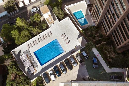 una vista aérea de dos piscinas junto a los coches aparcados en Apartamentos Buenos Aires By Mc, en Benidorm