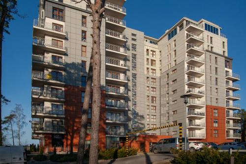 a tall apartment building with a tree in front of it at FEWO Sea View East Tower Porta Mare in Dziwnówek