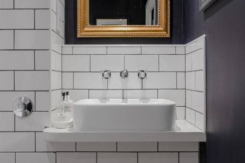 a white sink in a bathroom with a mirror at Chapel Loft in London