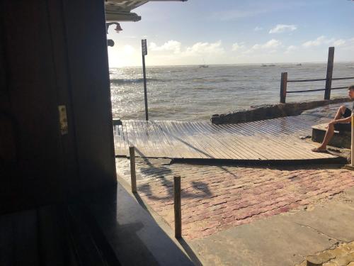 a person sitting on a bench looking at the ocean at Pousada Tranquila in Morro de São Paulo