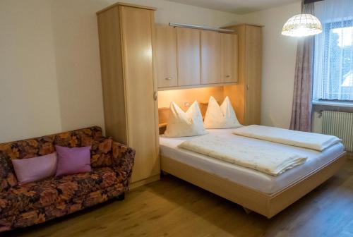 a bedroom with a bed and a couch at Haus Pfalzen - Casa Falzes in Falzes