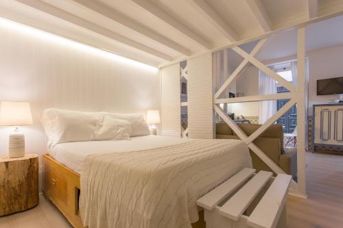 - une chambre blanche avec un lit et un banc dans l'établissement Soul of Lisbon - I, à Lisbonne