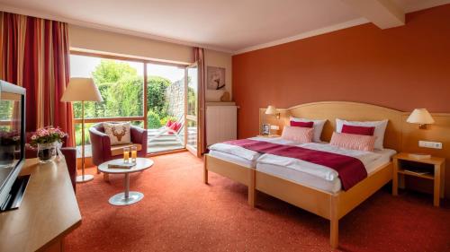 ein Hotelzimmer mit Bett und Balkon in der Unterkunft ANETSEDER Landhotel & Lofts in Thyrnau