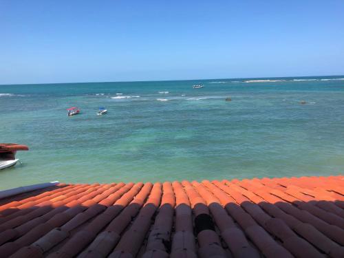 a view of the ocean with boats in the water at Pousada Tranquila in Morro de São Paulo