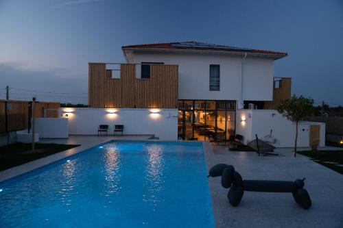 a swimming pool in front of a house at The Pines Boutique Villa - Vama Veche in Vama Veche