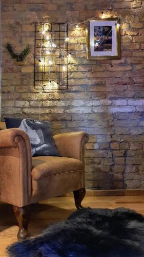 a living room with a couch and a brick wall at SummerStreetSeven in Budapest