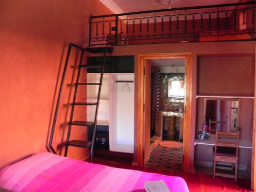 a bedroom with a bunk bed with a ladder at Kasbah Petit Nomade in Tinerhir