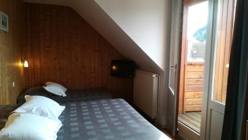a small room with a bed and a window at Hôtel Restaurant Les Tilleuls in Autrans