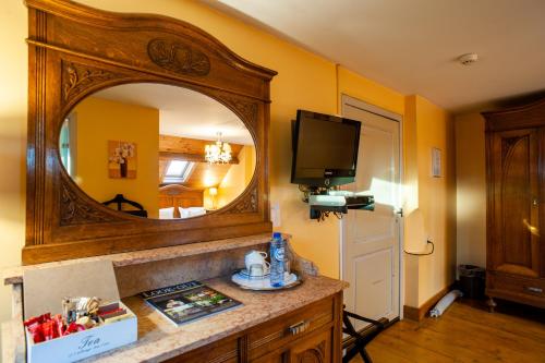 a kitchen with a sink, mirror and a television at Charme Hotel Hancelot in Ghent