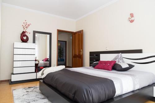a bedroom with a large bed with red pillows at Mar Rosa in Aguçadoura