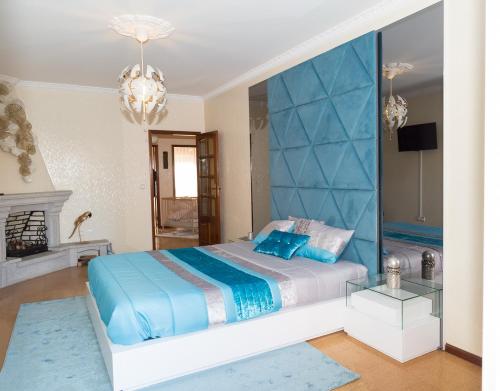 a bedroom with a bed with a blue headboard at Mar Rosa in Aguçadoura